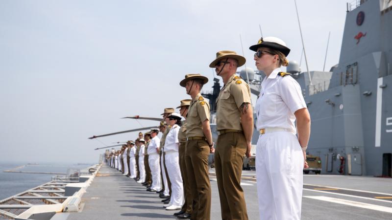 Royal Australian Navy and Australian Army personnel fall in for Procedure Alpha on the flight deck of HMAS Adelaide as the ship comes alongside in Jakarta, Indonesia, during Indo-Pacific Endeavour 2024.