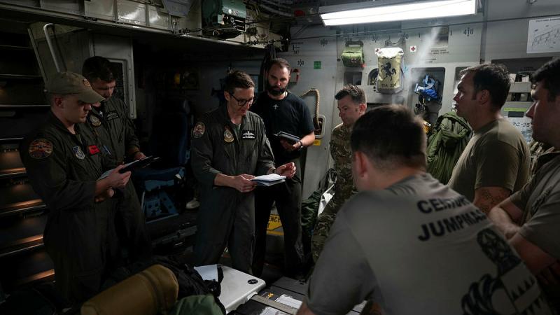  Flight Lieutenant Tom Breadon from the RAAF’s 36 Squadron briefs mission details before a joint airdrop mission over Alaska. 