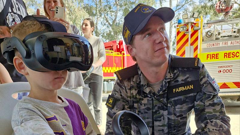 Seaman Scott Fairman guides a child through a ship-based virtual reality activity during the Hastings Fire Brigade family day. Photos: Acting Sub-Lieutenant Jonathan Rendell