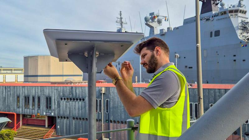Pierre de Vallier, of the Enhanced Quality of Life Team, Navy Intelligence and Information Warfare, installs a Starlink system on board HMAS Brisbane.
