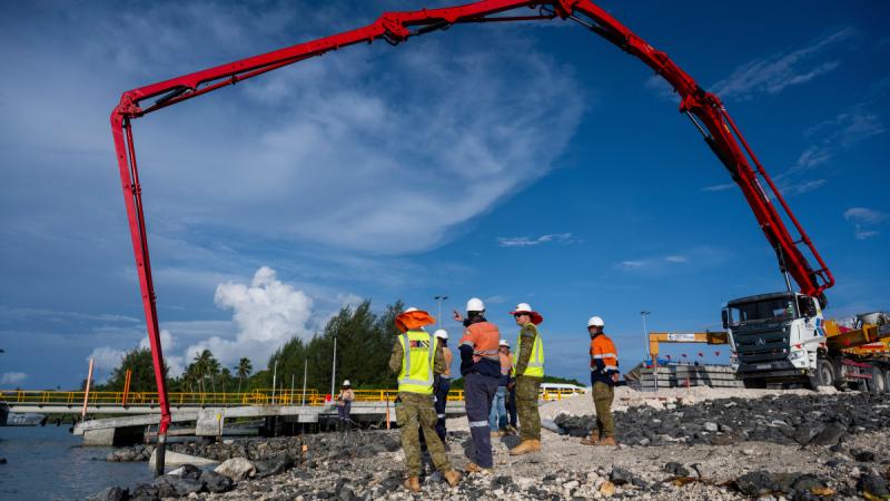 Australian Army officers Captain Will Guelen and Captain Max Cubis, of 12th Chief Engineer Works, oversee the concrete pour for the boat ramp under construction at Lombrum Naval Base, PNG.