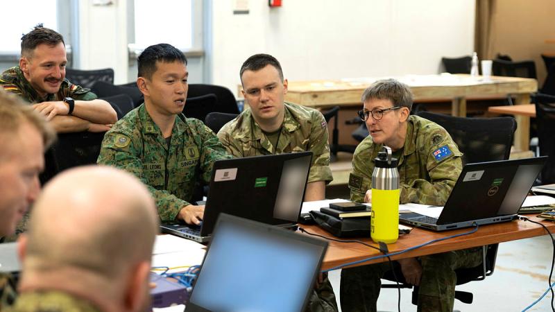 Australian Army Civil Military Coordination Planner of 2nd (Australian) Division, right, Captain Louise Broadfoot plans with multinational partners during a U.S. Marine Corps Information Warfighter Exercise, in Quantico, Virginia. 