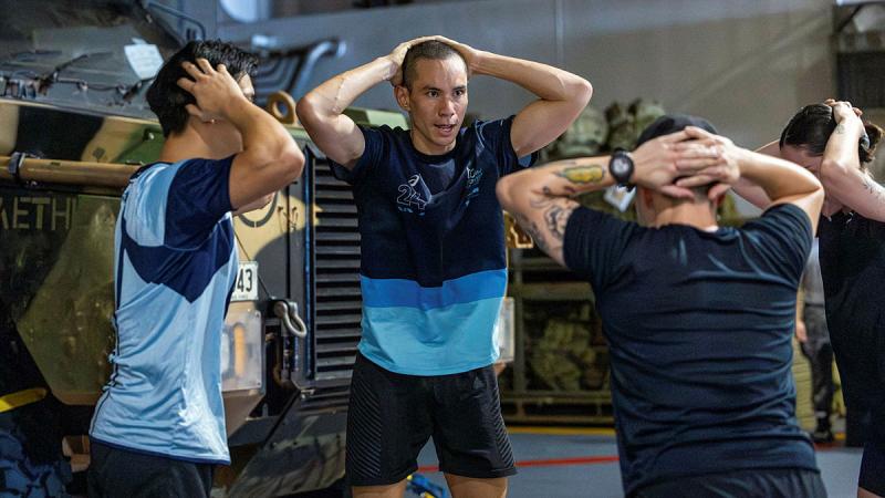 Defence personnel participate in the workout-of-the-day competition on HMAS Adelaide.