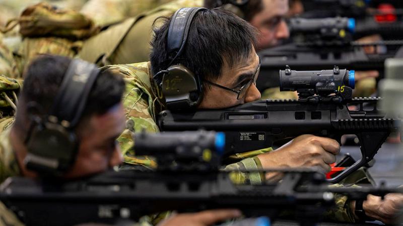 Air Force chef, Leading Aircraftman Henry Lam from 23 Squadron, centre, at the weapons training simulation system at RAAF Base Amberley, Queensland. 