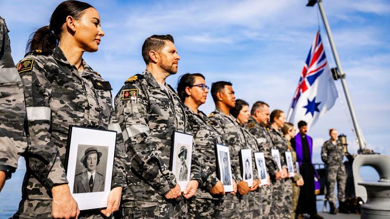  Nursing Officers at the Bangka Island Massacre memorial service on board HMAS Adelaide hold photos of those who lost their lives in 1942. 