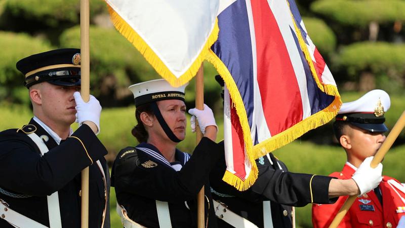  Able Seaman Alexandra Manthey, second from left, holds a UK flag during a ceremony in Busan, South Korea. 