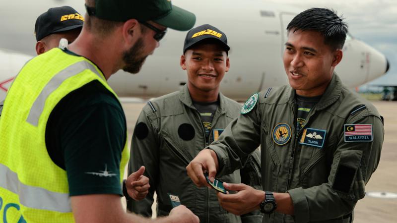 A member of the Royal Australian Air Force trades a patch with a member of the Royal Malaysian Air Force during an engagement day at RMAF Butterworth as part of Operation Gateway.