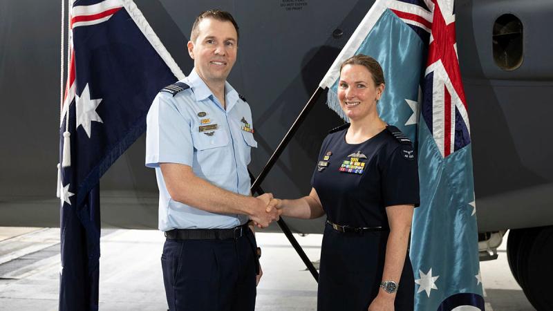 Outgoing Commanding Officer for 37 Squadron, Wing Commander Charles Freebairn, congratulates incoming Commanding Officer Wing Commander Dianne Bell during their Change of Command ceremony. 