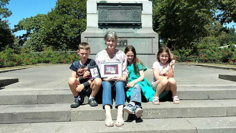 Mrs Karen Curtis (nee O’Shea) with her grandchildren, holds the World War 2 service medals of her great uncle William O’Shea at the Timaru War Memorial in New Zealand. 