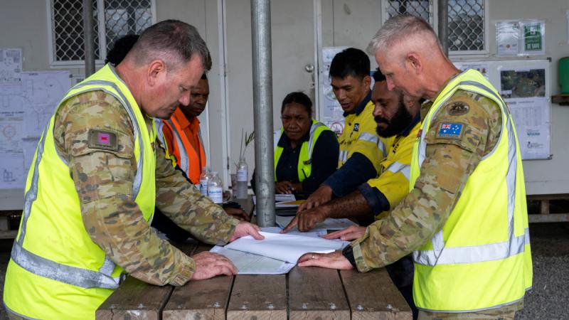 Australian Army soldiers WO2 Bryan Griff and WO2 Paul Thornhill gather with contractors from Reeves Envico and Hebou to discuss the progress of the PNGAus Partnerships’ Potable Water Infrastructure Works at the PNG Defence Force’s Goldie River Training Depot, PNG.
