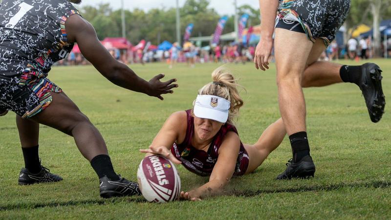 ADF Touch premier team captain Leading Aircraftwoman Nina Sherlock dives forward to score a try between two defenders during the Bundaberg Cup in early February.