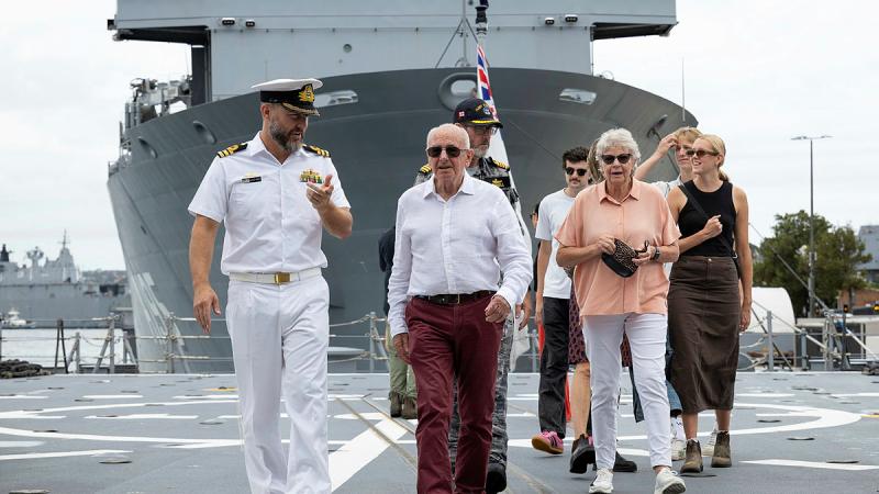 Naval officer Commander Bernard Dobson leads Vice Admiral Donald Chalmers, AO (Retiredd) and his family on board HMAS Brisbane alongside Fleet Base East in Sydney, New South Wales.