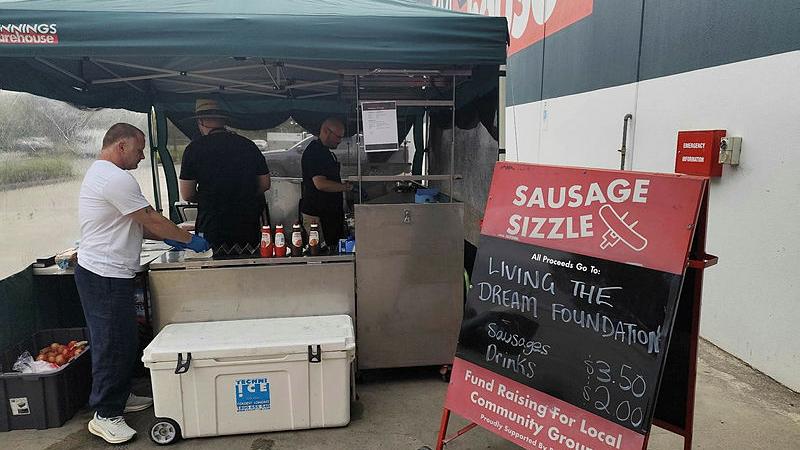 Navy Recruit School members run a Bunnings sausage sizzle at Hastings in Victoria for the Living the Dream Foundation.