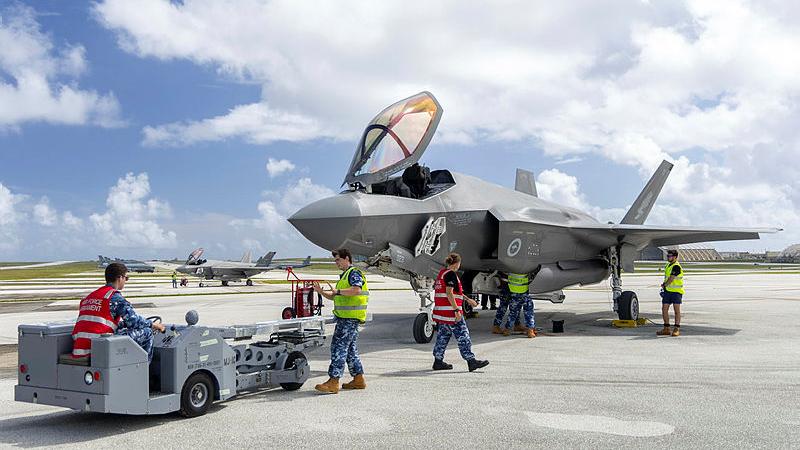 Royal Australian Air Force armament technicians in high-vis vests load explosive ordnance to an F-35A Lightning II aircraft during Exercise Cope North 25, at Andersen Air Force Base, Guam.