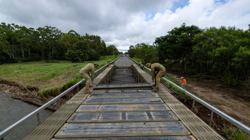 Soldiers from 3rd Combat Engineer Regiment assemble a medium girder bridge at Ollera Creek, Townsville, during Defence Assistance to the Civil Community following severe weather and flooding across the region.