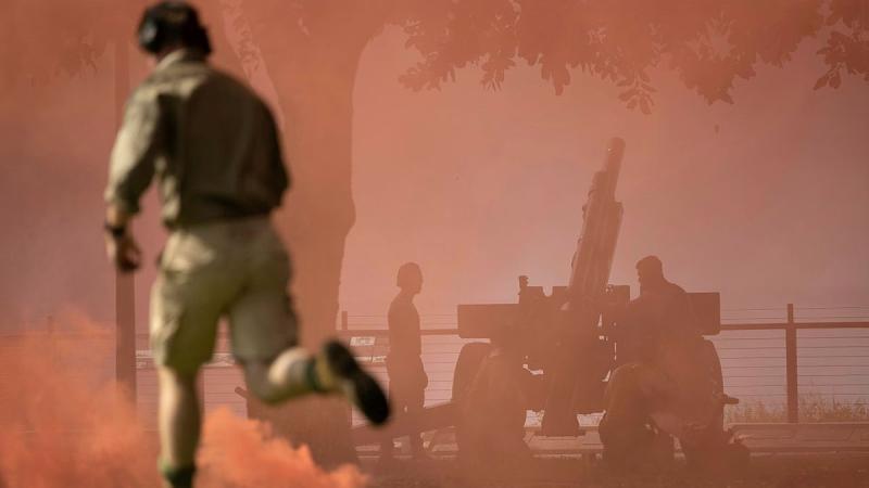 Gunners from 102nd Battery, 8th/12th Regiment, Royal Australian Artillery participate in the re-enactment of the Bombing of Darwin, amid red smoke and haze.