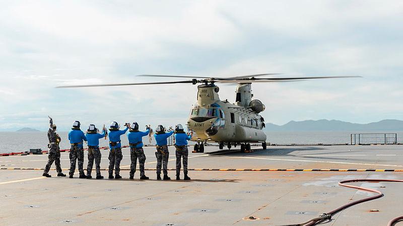 Members of HMAS Choules’ flight deck team prepare an Army CH-47 Chinook for take-off during deck landing practice while off the coast of Townsville. Photos: Able Seaman Danyellah Hill