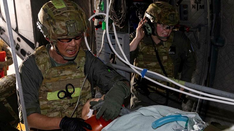 RAAF officer Squadron Leader Kim Lim, left, from 3 Aeromedical Evacuation Squadron, fits a simulated patient with a bag-valve-mask ventilator on board a C-27J Spartan during the Force Generation Culminating Activity at RAAF Base Amberley.
