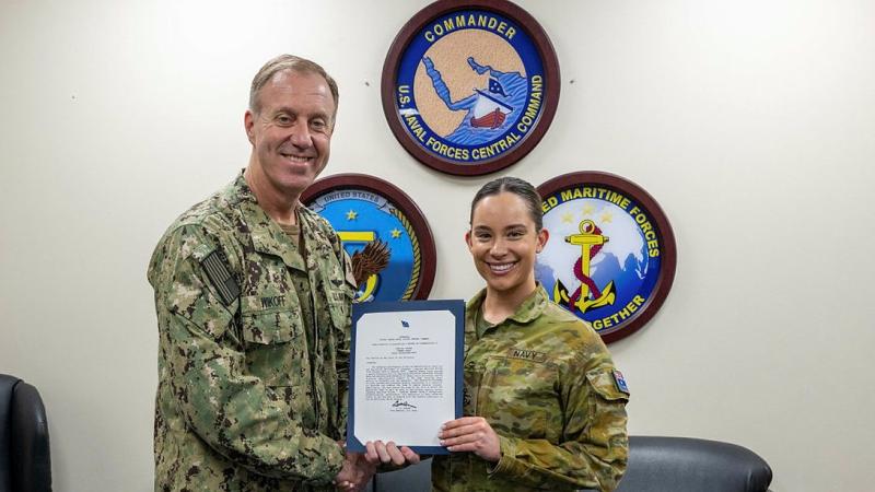 Commander United States Naval Forces Central Command and Commander Combined Maritime Forces, Vice-Admiral George M. Wikoff presents a certificate of commendation to Royal Australia Navy Leading Seaman Summer Vardy for exemplary service while deployed to the Middle East. 
