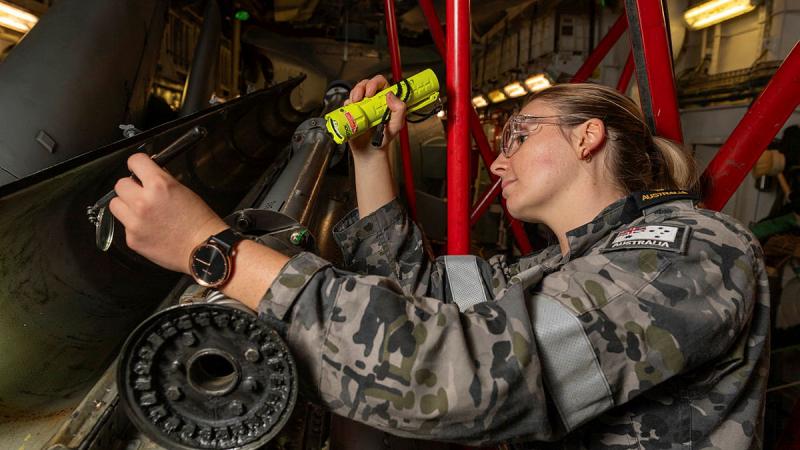Able Seaman Phoebe Poole from 808 Squadron's 801 Flight, works on the embarked MH-60R-Sea Hawk helicpoter, aboard HMAS Arunta, ahead of the ship's Navy Week open day in the Port of Melbourne. 