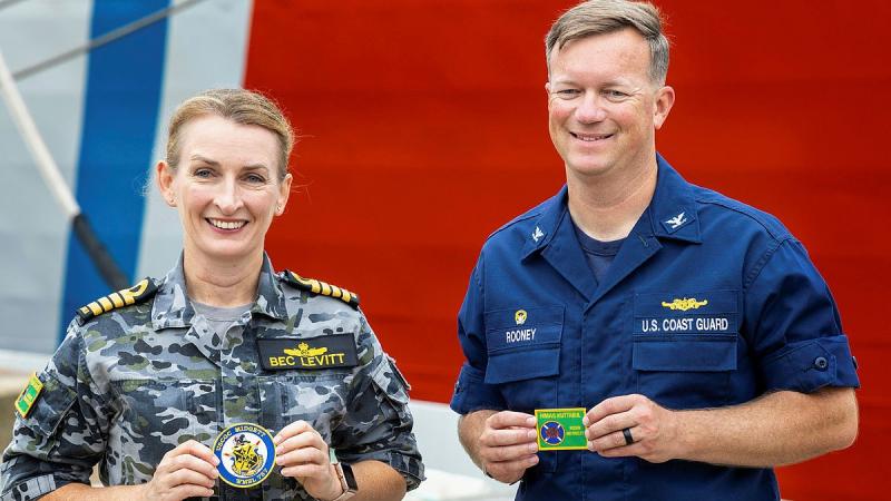 Captain Rebecca Levitt, Commanding Officer HMAS Kuttabul, swaps shoulder patches with Captain Matthew Rooney, Commanding Officer USCGC Midgett, alongside Garden Island Defence Precinct during Midgett's visit to Sydney.