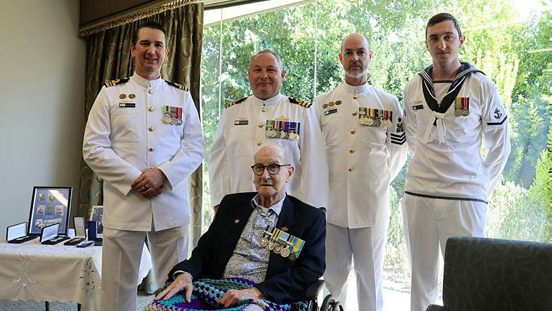 HMAS Encounter's Commanding Officer Commander Tony Ryder presents veteran Able Seaman Colin Cherry with his medals for Naval service during the Koean War, surrounded by Lieutentant Commander Gavin Colgan, Petty Officer Warren Sanders and Leading Seaman Dylan Sanders.