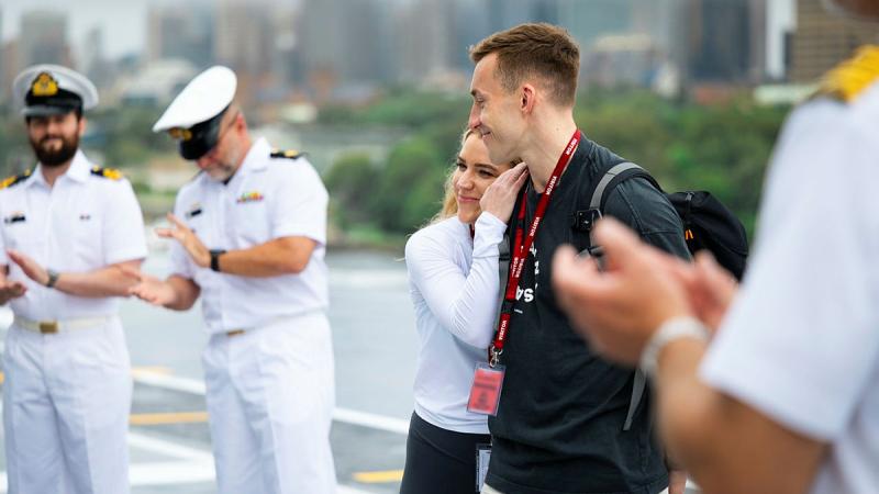 Elinor Thomas and Thomas Watkins, centre, thank HMAS Canberra personnel during a tour of the ship while alongside Fleet Base East in Sydney. 