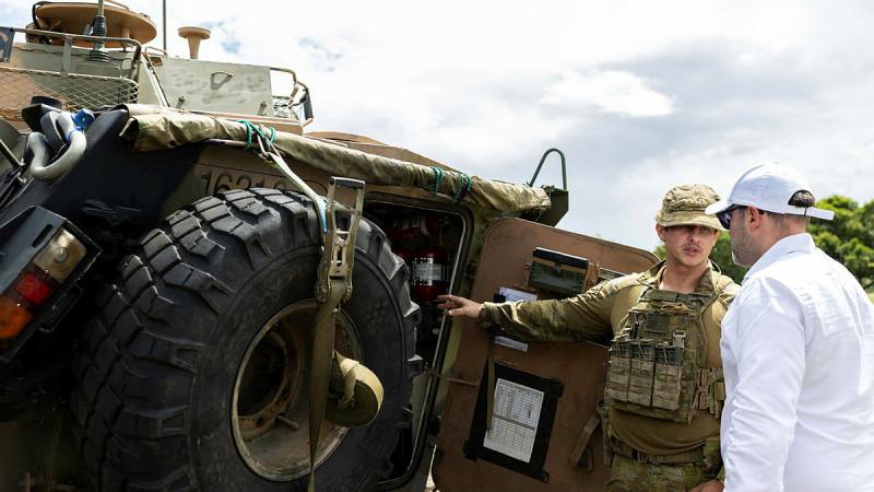 A soldier from 2nd Cavalry Regiment talks with an executive from the Australian Industry Group during a visit to Lavarack Barracks. 