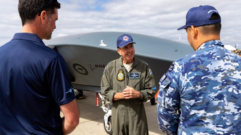 Wing Commander Phil Parsons from the Collaborative Autonomous Systems Project Office, speaks with aviators and representatives from Boeing about the capabilities of the Boeing MQ-28 at the Australian International Airshow 2025.
