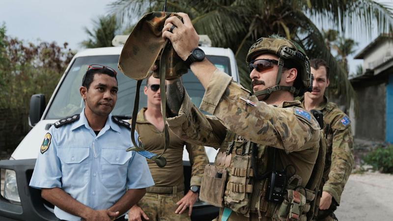 Sergeant Matthew Watson (centre) from 20th Explosive Ordnance Disposal Squadron prepares the miniature remote answer back system to render safe the unexploded ordnance during Operation Render Safe 25-B Nauru. 