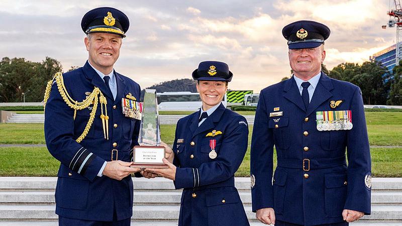 The Chief of Air Force Air Marshal Stephen Chappell (left) and Warrant Officer of the Air Force Ralph Clifton (right) present the Chief of Air Force Instructor of the Year Award to Flight Lieutenant Skye Emsley. 