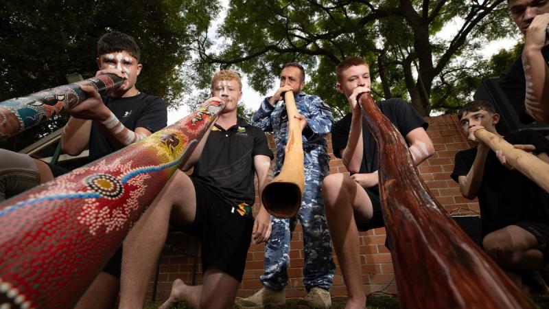 Indigenous Liaison Officer, Sergeant Ron Schultz, plays the Yidaki (didgeridoo) alongside students from Richmond High School during a National Reconciliation Week morning tea held at RAAF Base Richmond.