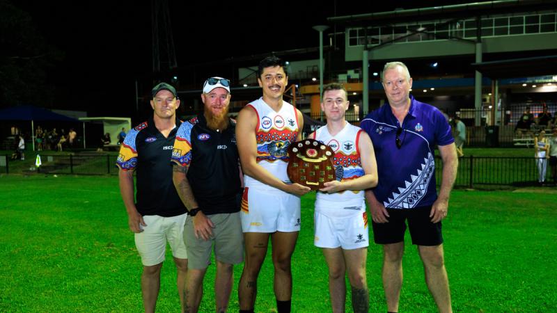 The NT ADF men's team holds the 2025 Anzac Shield cup with Commander 1st Brigade, Brigadier Doug Pashley, and Assistant Commissioner Matthew Hollamby, of the NT Police, Fire & Emergency Services, at TIO Stadium 2, Darwin. 