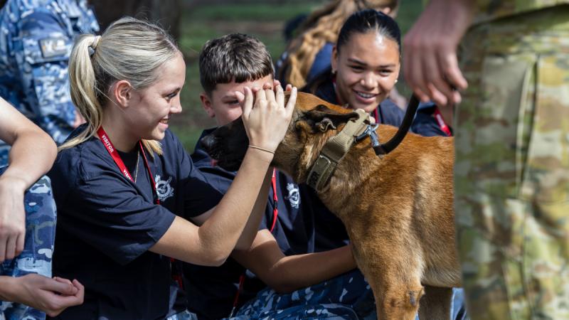 Participants in the Indigenous Youth Work Experience Program meet retired military working dog 'Ryder' at RAAF Base Williamtown, NSW.