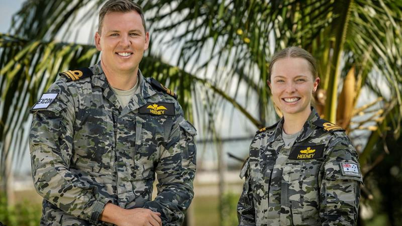Lieutenant Barton Heeney, from Fleet Aviation, and Lieutenant Jacqui Heeney, from Fleet Cyber Unit, at Headquarters Integrated Area Defence System during Exercise Bersama Shield 2025, under the palm trees at Royal Malaysian Air Force Base Butterworth, Malaysia..