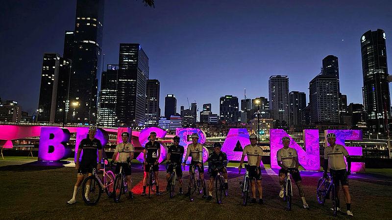  ADF cyclists in front of a Brisbane sign and skyline during the Tour de Brisbane.