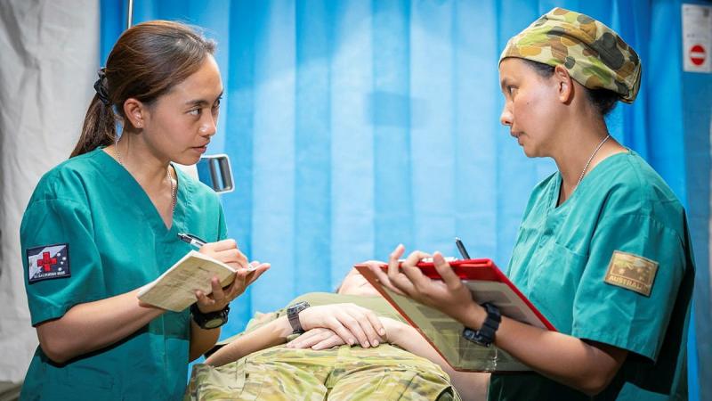 Captain Krezeil Lacorte and Captain Novie Pagaduan, from 3rd Health Battalion, document patient information in the Role 2 Basic Facility at Antonio Bautista Air Base, Palawan, Philippines, on Exercise Balikatan.