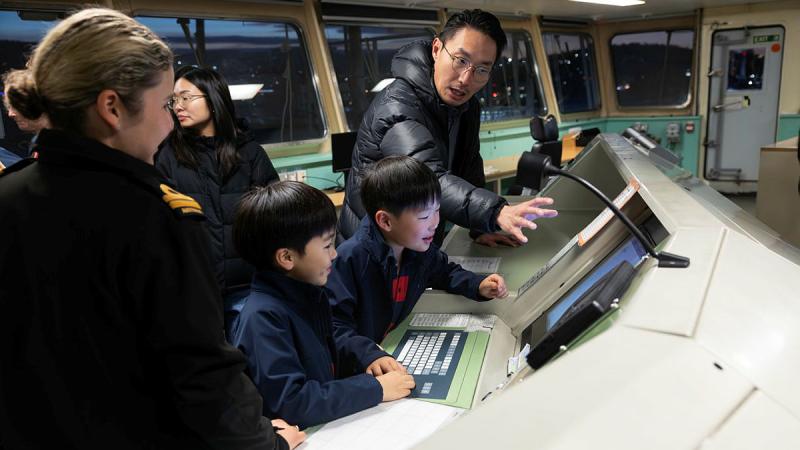 Lieutenant Ashley Churchin shows members of the public the systems on the bridge on board HMAS Choules during an open day held in Hobart. 