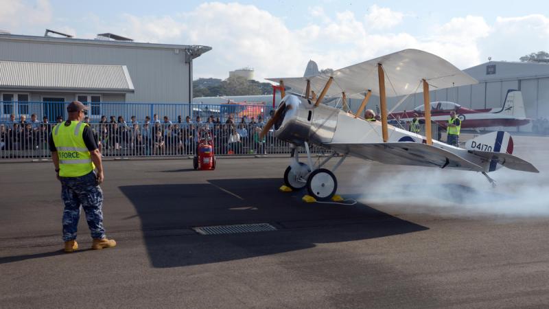 RAAF 100 Squadron senior aircraft maintenance engineer David Jones starts a Sopwith Pup replica with help from Corporal John Newell for Year 3 Point Cook P-9 College staff and students at the RAAF Museum. 