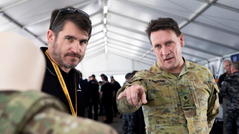 Head of Military Strategic Plans, Major General Colin Karotam, talks with defence industry professionals during Exercise Autonomous Warrior 2022 at HMAS Creswell, Jervis Bay, Australian Capital Territory.