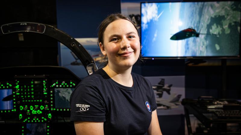 Lily Hemmings experiences an F/A-18 simulator at Fighter World during a tour of RAAF Base Williamtown for the Women in Aviation Program.