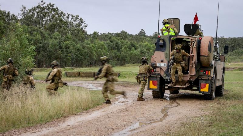 Aviators from 2 Security Forces Squadron disembark from a Bushmaster during a live-fire section attack activity as part of Exercise Crack Thump 3 at Singleton Military Area.