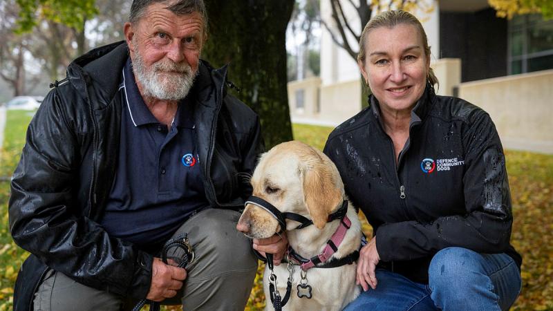 Peter Mengel with his Labrador Peaches and Defence Community Dogs Managing Director Leanne Kyle during a Defence Community Dogs awareness day at Russell Offices, Canberra. 