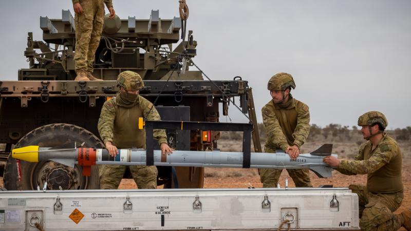 Soldiers from the 16th Regiment, Royal Australian Artillery, load Sidewinder missiles on a NASAMS High-Mobility Launcher at Woomera Test Range, South Australia.