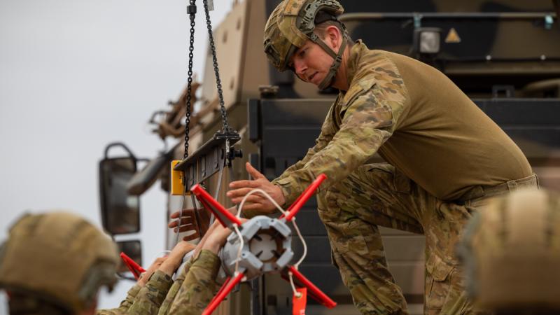 Australian Army soldier Gunner Thomas Hayes, from 111 Battery, 16th Regiment, Royal Australian Artillery, helps load a Sidewinder missile on a NASAMS High-Mobility Launcher during a live-fire certification activity at Woomera Test Range, South Australia.