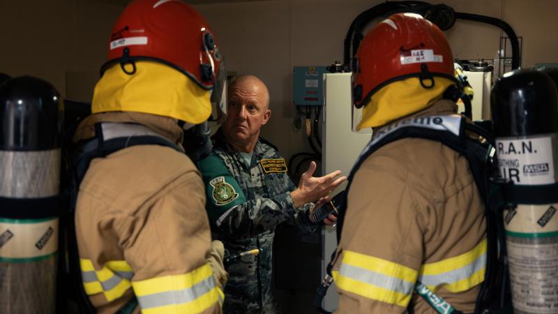 Members of HMAS Canberra's Standing Sea Fire and Emergency Party conduct damage control training with Chief Petty Officer Andrew Gibson from Sea Training Group during a transit to Wellington, New Zealand.