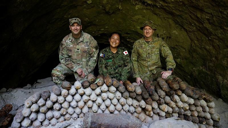 US Army, Japan Self-Defense Force and Australian Army personnel pose with a pile of Second World War-era unexploded ordnance in a cave in East New Britain, Papua New Guinea.