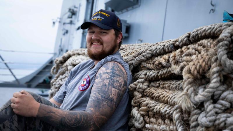 Marine technician Able Seaman Harley Orpin displays his HMAS Sydney tattoo onboard Sydney during Regional Presence Deployment 25-2.