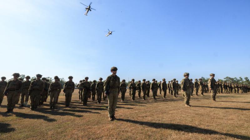 Soldiers of the 5th/7th Battalion, Royal Australian Regiment, on parade with Army Reconnaisance Helicopters from 1st Aviation Regiment during the Battle of Binh Ba commemoration service held in Darwin.