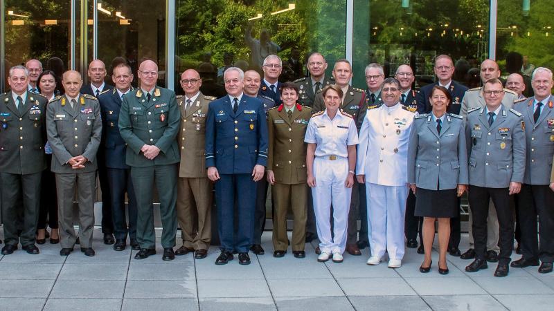 Group shot of military and civilian personnel in front of a building in Washington.